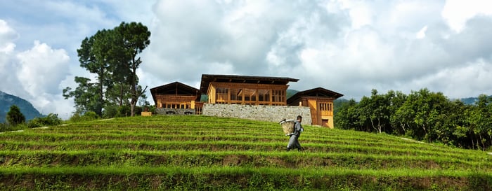 A man walking in the rice paddies surrounding COMO Punakha Bhutan