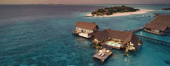 Aerial view over COMO Cacao Island water villas in the Maldives
