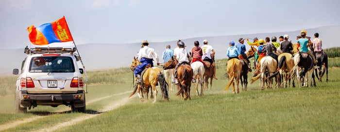  ? People on horseback and an SUV in the Mongolian steppe during the Naadam festival 