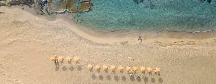 Aerial image of a beach with sun loungers and parasols in Greece