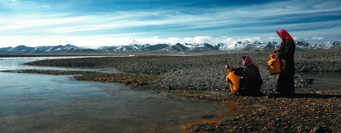 Women gathering water at a lake, luxury holidays to Tibet