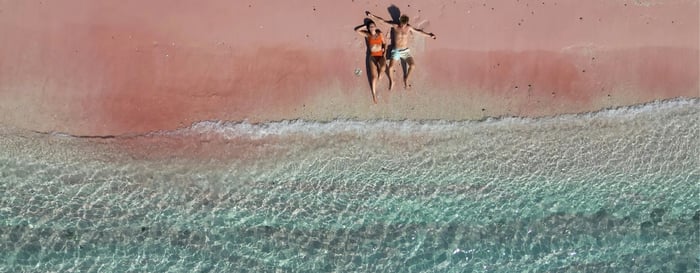 couple lying on pink beach in komodo island indonesia