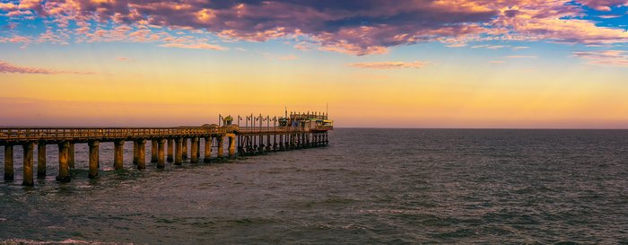 Colorful sunset over the old historic jetty in Swakopmund, Namibia.