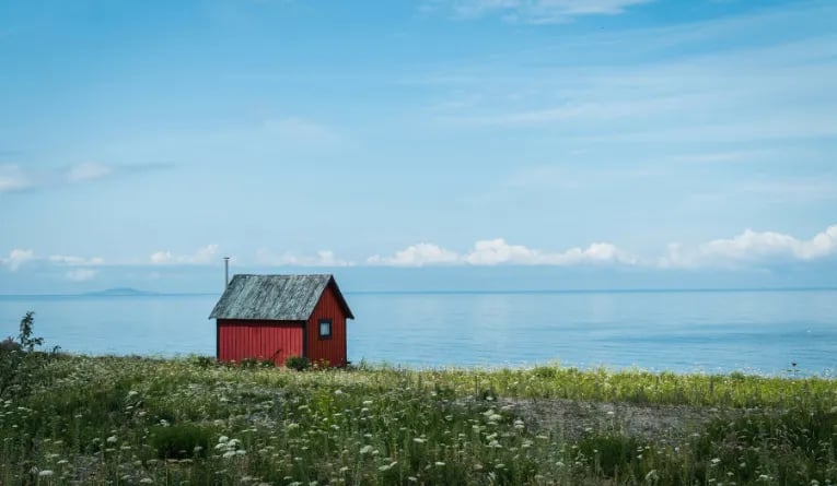 little red cabin on a lake in sweden