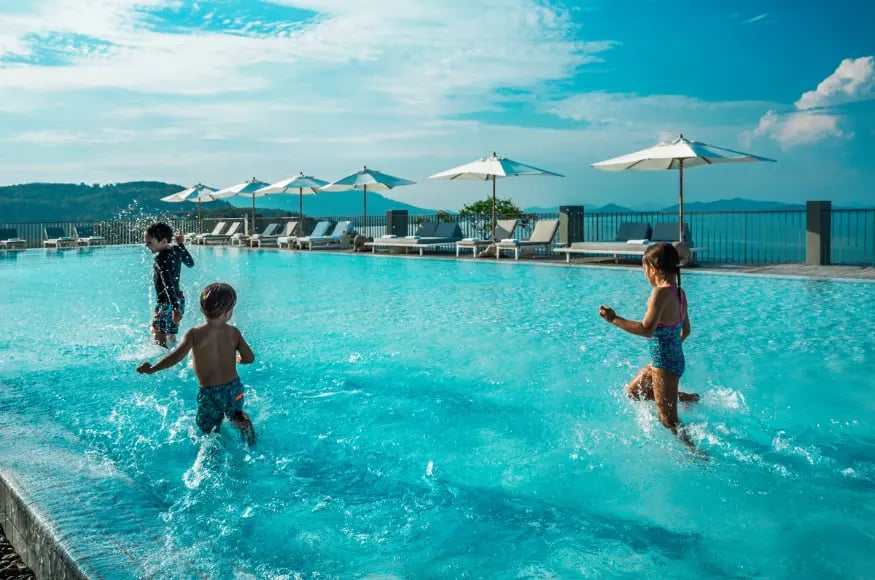 Children splashing in a luxury hotel pool in Thailand