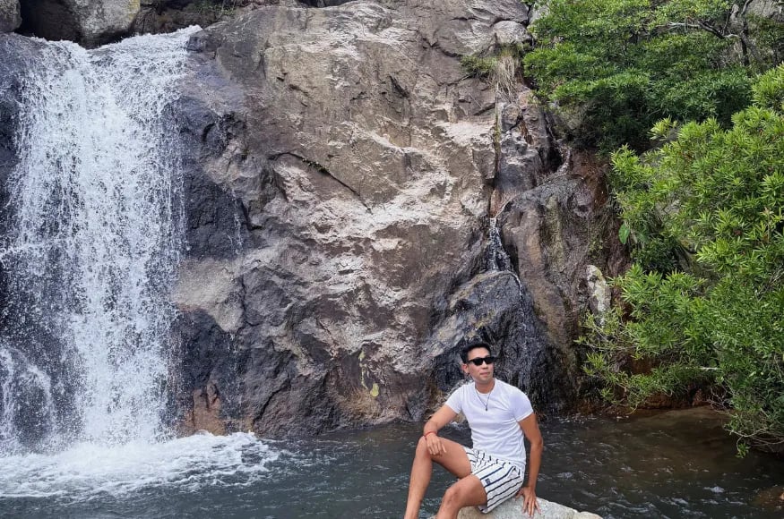 Man sitting at a waterfall
