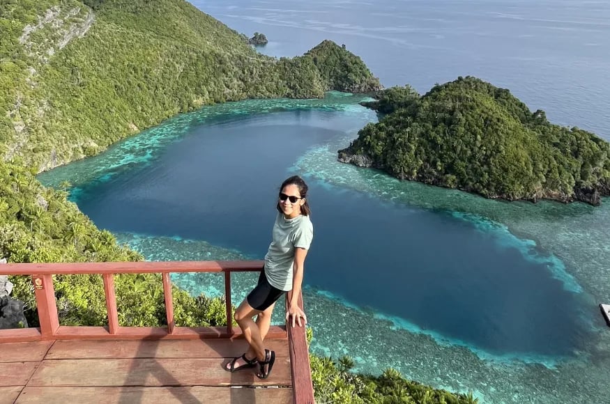 A woman standing on an observation deck in Raja Ampat