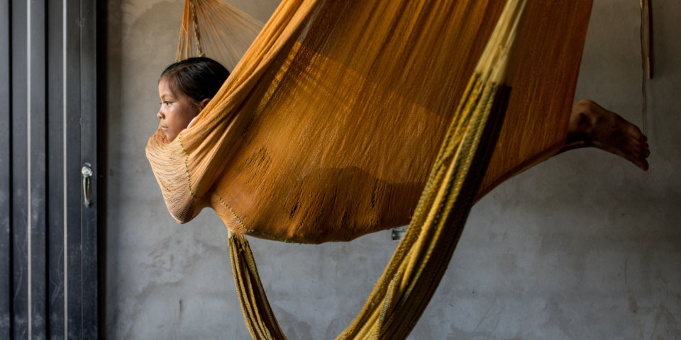 Wendy, looks through a window in her home at Orocué, Casanare.